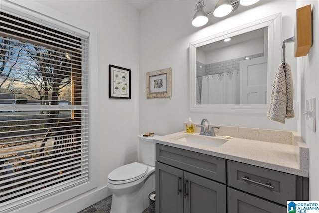 bathroom featuring curtained shower, vanity, and toilet