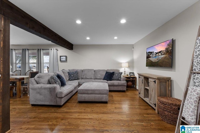 living room featuring dark wood-type flooring and beamed ceiling