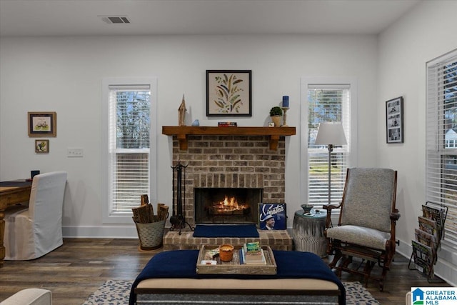 sitting room featuring a fireplace and dark wood-type flooring