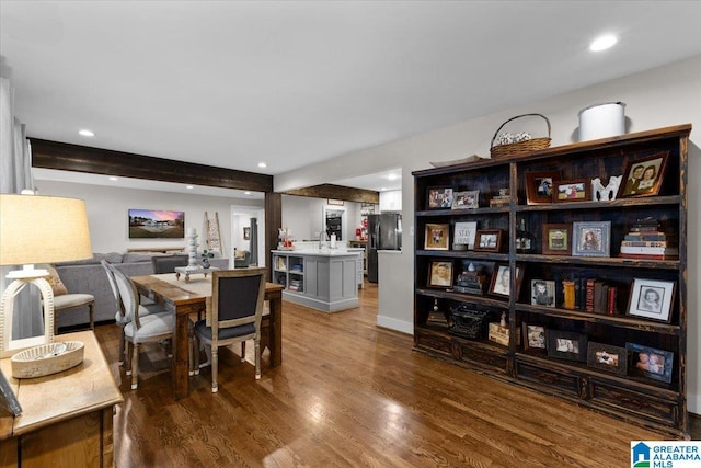 dining room with hardwood / wood-style flooring, beamed ceiling, and sink