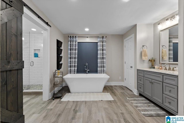 bathroom featuring separate shower and tub, hardwood / wood-style floors, and vanity