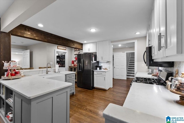 kitchen featuring black appliances, beamed ceiling, dark hardwood / wood-style flooring, decorative backsplash, and white cabinets