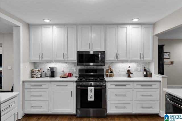 kitchen featuring appliances with stainless steel finishes, backsplash, dark hardwood / wood-style flooring, and white cabinetry