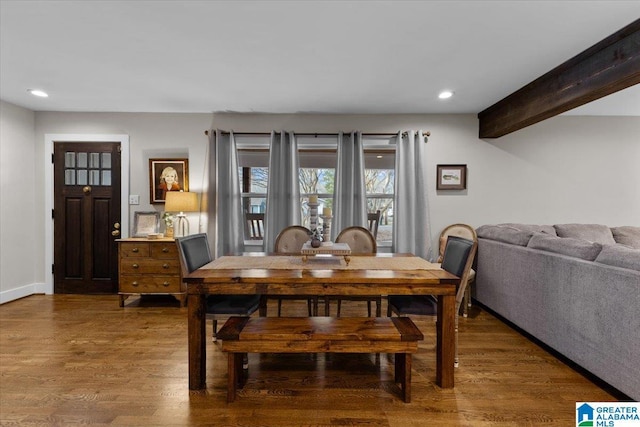 dining space featuring dark wood-type flooring and beam ceiling