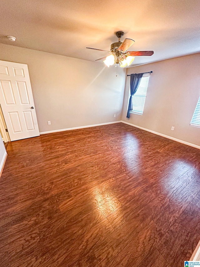 spare room with ceiling fan and dark hardwood / wood-style floors