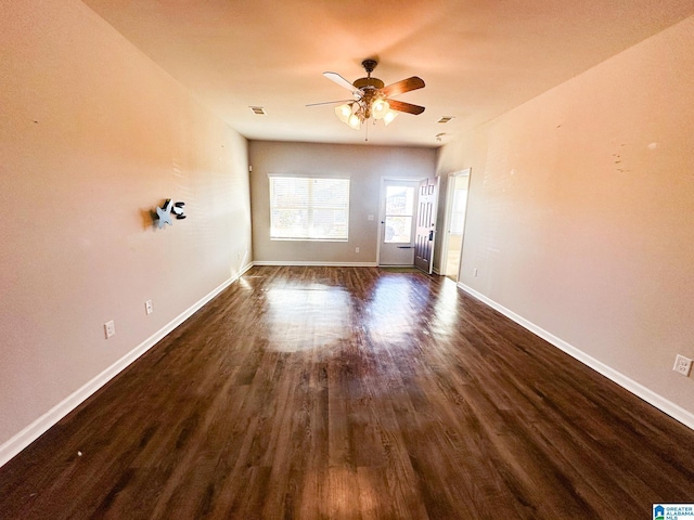 empty room with dark wood-type flooring and ceiling fan