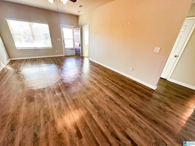 empty room with ceiling fan and dark wood-type flooring