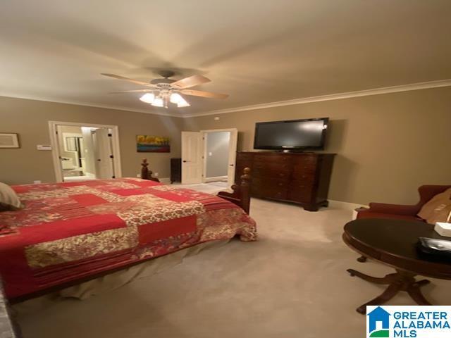 bedroom with light carpet, crown molding, and ceiling fan