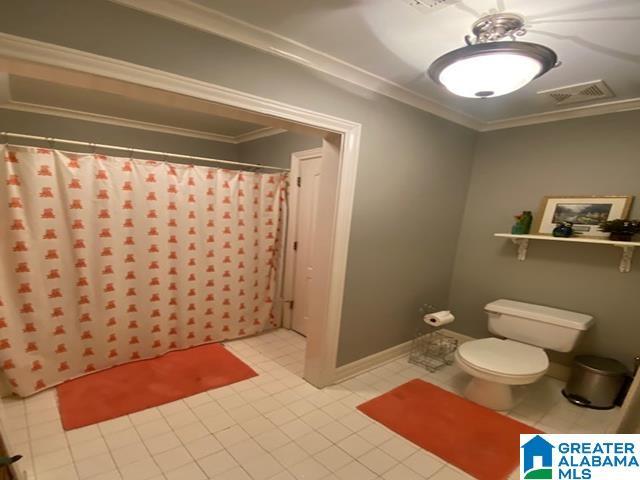 bathroom with crown molding, a shower with curtain, and toilet