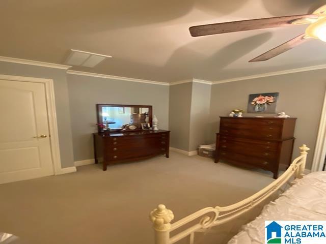 carpeted bedroom featuring ceiling fan and ornamental molding