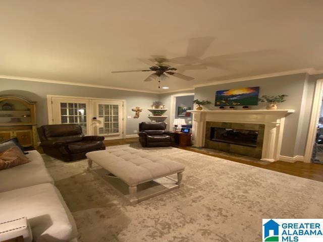 living room featuring hardwood / wood-style floors, french doors, ceiling fan, and ornamental molding