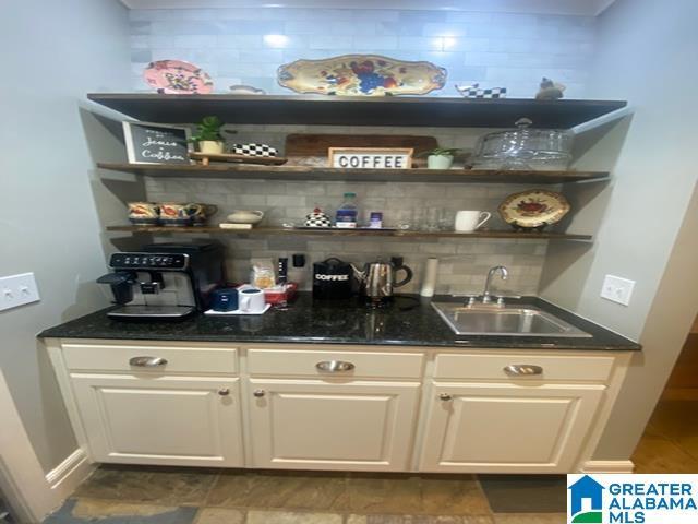 bar featuring white cabinets, sink, and decorative backsplash