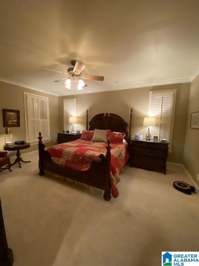 carpeted bedroom with ceiling fan and ornamental molding