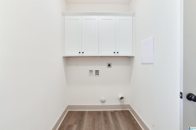 laundry room with hardwood / wood-style flooring, hookup for an electric dryer, hookup for a washing machine, cabinets, and gas dryer hookup