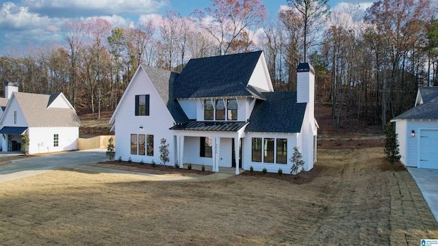 modern farmhouse featuring a front lawn and a garage