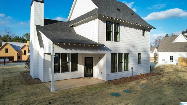 rear view of property featuring a patio and a yard