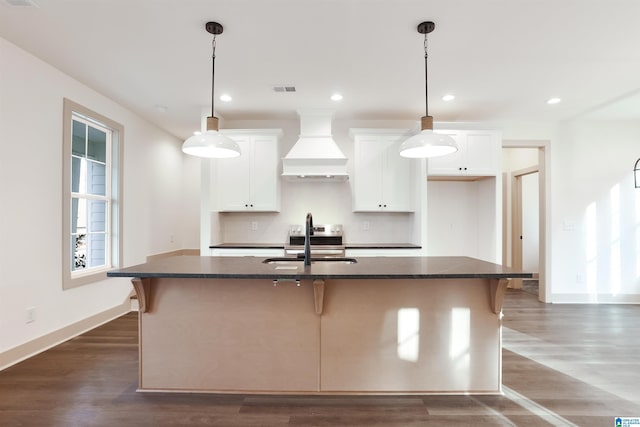 kitchen featuring custom exhaust hood, an island with sink, dark hardwood / wood-style flooring, white cabinets, and sink