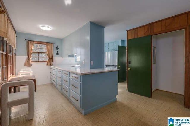 kitchen featuring stainless steel refrigerator and kitchen peninsula