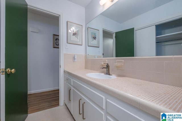 bathroom with hardwood / wood-style flooring, backsplash, and vanity