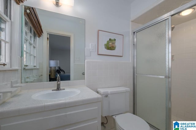 bathroom featuring tile walls, an enclosed shower, toilet, and vanity