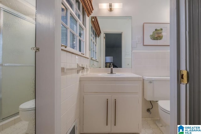 bathroom featuring tile walls, walk in shower, vanity, and toilet