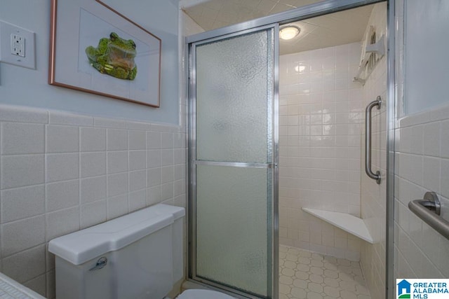 bathroom with toilet, walk in shower, and tile walls