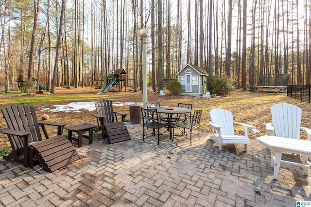 view of patio with a playground, a shed, and a trampoline