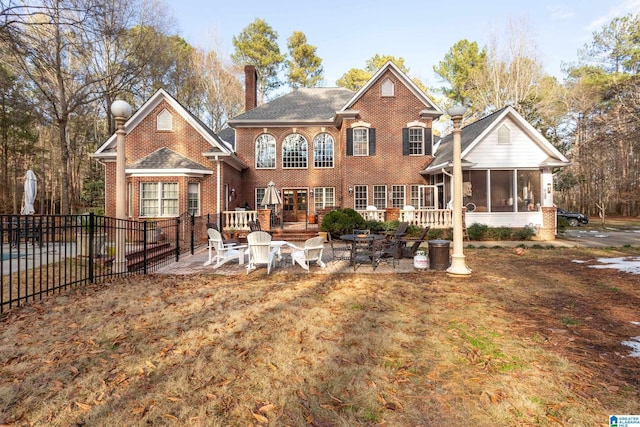 rear view of property featuring a sunroom and a patio