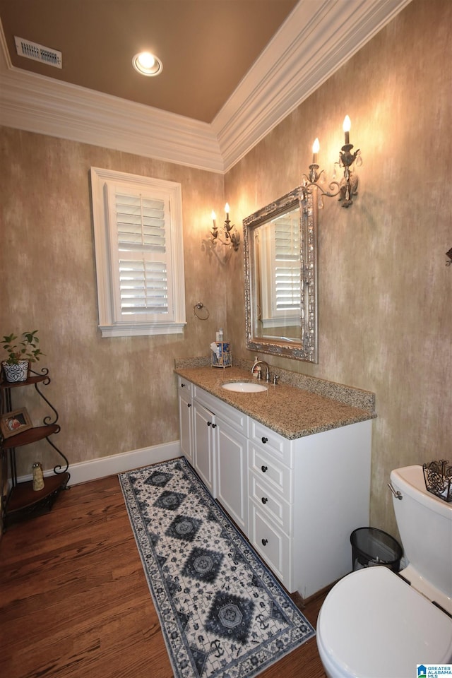 bathroom with toilet, ornamental molding, wood-type flooring, and vanity