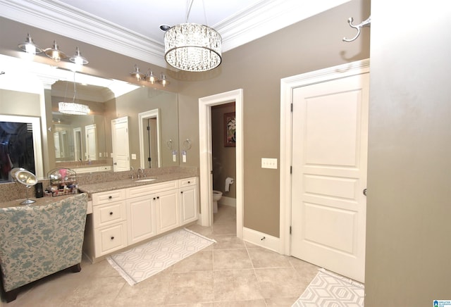 bathroom with tile patterned flooring, toilet, vanity, crown molding, and a notable chandelier