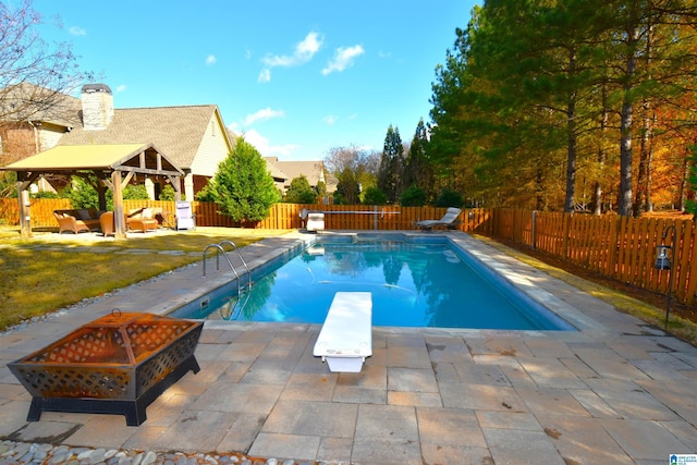 view of swimming pool with an outdoor living space with a fire pit, a patio, a diving board, and a gazebo