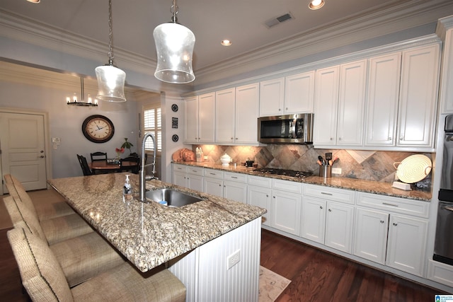 kitchen with appliances with stainless steel finishes, white cabinets, and a center island with sink