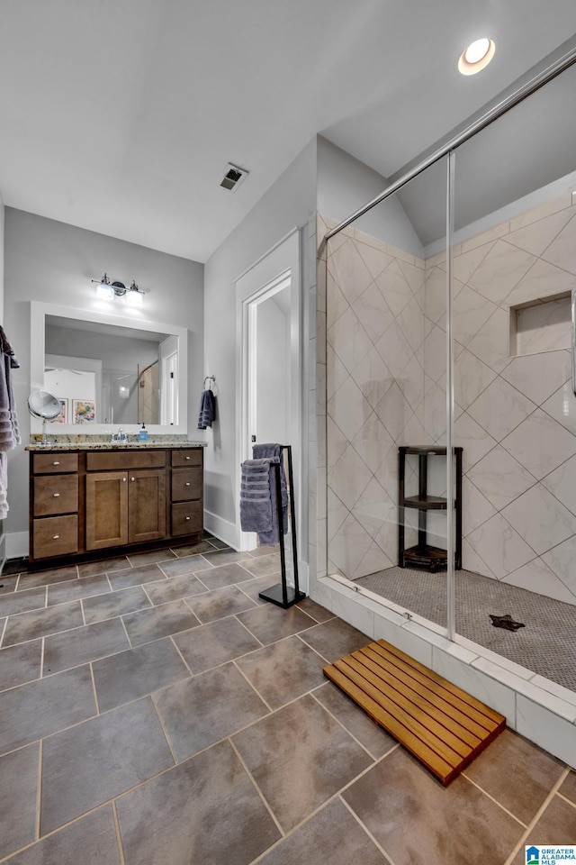 bathroom featuring tiled shower and vanity