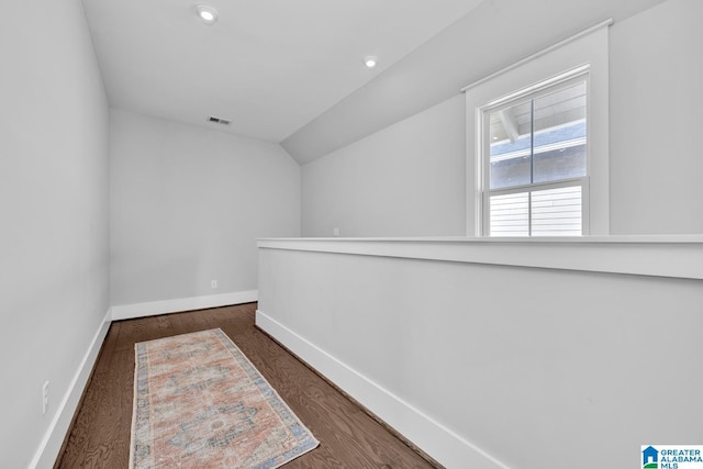 interior space featuring dark hardwood / wood-style flooring and vaulted ceiling