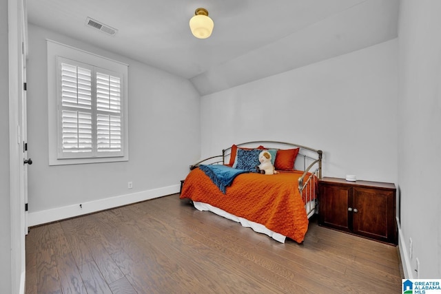 bedroom with lofted ceiling and hardwood / wood-style floors