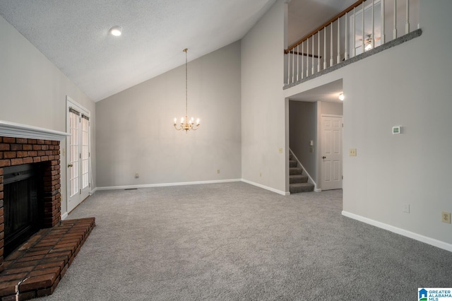 unfurnished living room with a textured ceiling, carpet floors, a fireplace, a chandelier, and high vaulted ceiling