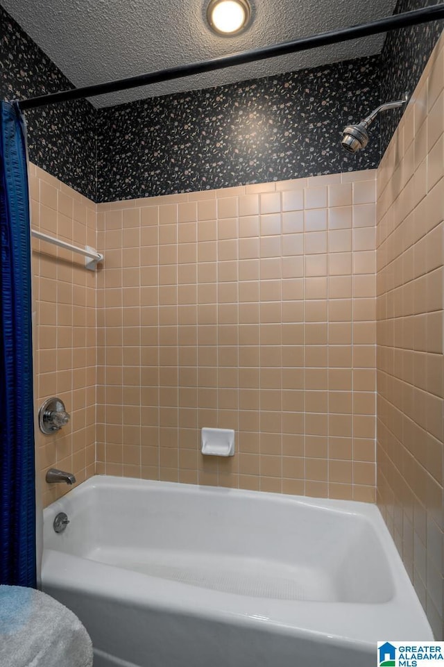 bathroom featuring shower / tub combo and a textured ceiling