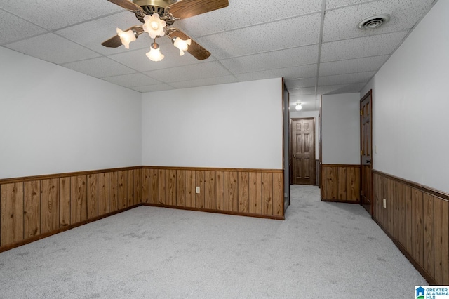 carpeted spare room featuring ceiling fan and a drop ceiling