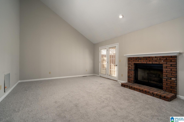 unfurnished living room with high vaulted ceiling, a fireplace, and carpet flooring