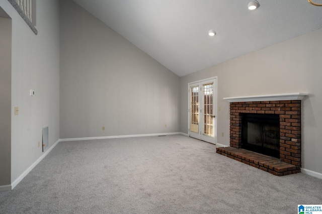 unfurnished living room featuring a brick fireplace, carpet flooring, and vaulted ceiling