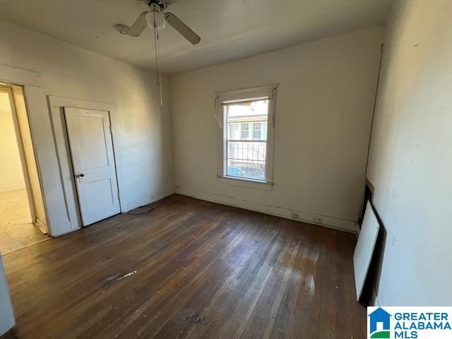 empty room with dark wood-type flooring and ceiling fan