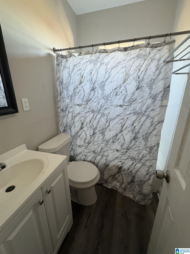 bathroom featuring toilet, vanity, and hardwood / wood-style floors