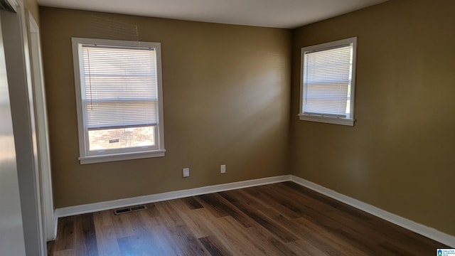 unfurnished room with dark hardwood / wood-style flooring