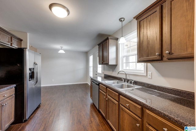 kitchen featuring stainless steel appliances, dark hardwood / wood-style flooring, sink, and pendant lighting