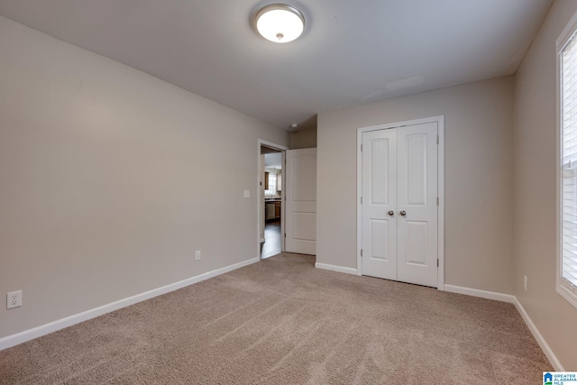 unfurnished bedroom with a closet, carpet flooring, and multiple windows