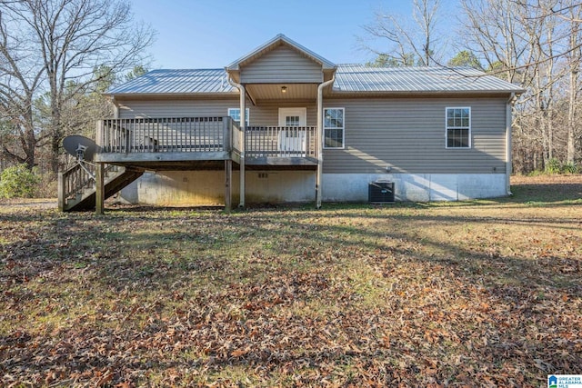 rear view of house with a yard, a wooden deck, and central AC unit