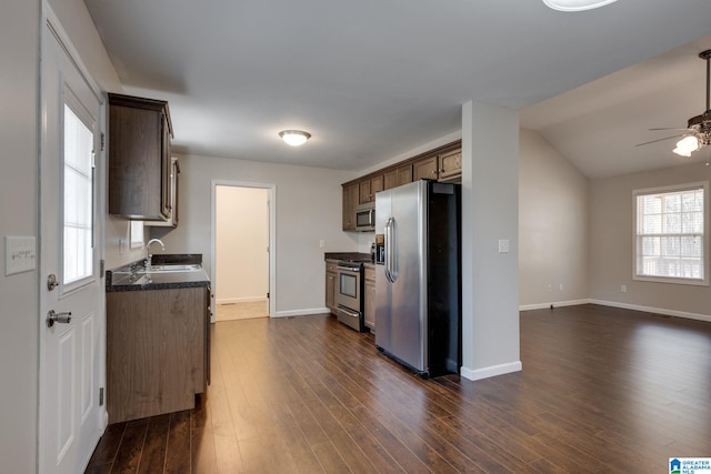 kitchen featuring vaulted ceiling, stainless steel appliances, dark hardwood / wood-style flooring, ceiling fan, and sink