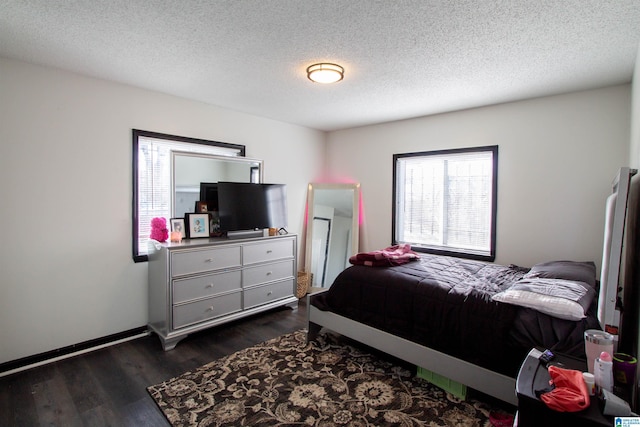 bedroom featuring dark hardwood / wood-style flooring and a textured ceiling