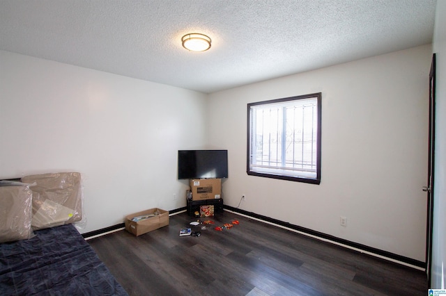 unfurnished bedroom featuring a textured ceiling and dark hardwood / wood-style floors