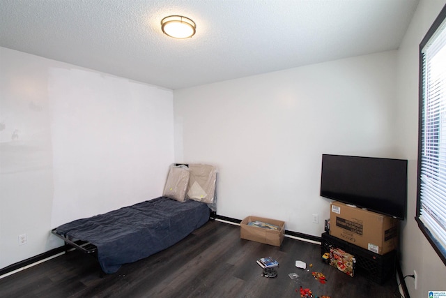 bedroom featuring dark wood-type flooring and a textured ceiling